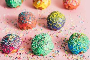 beignets colorés avec des brins de sucre sur un fond en désordre photo