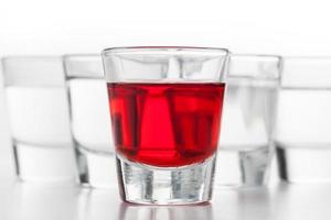 verres d'alcool. l'un aromatisé au rouge, les autres à la vodka propre. photo