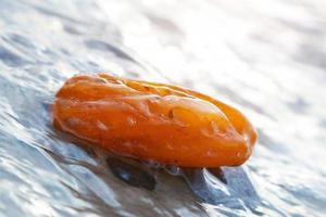 pierre d'ambre dans les vagues. gemme précieuse, trésor. mer Baltique photo