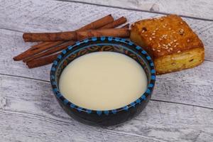 lait concentré dans le bol avec sinnamon et pâtisserie photo