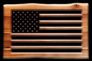 le drapeau américain coupé dans une planche de bois, plaque isolée sur fond noir. photo