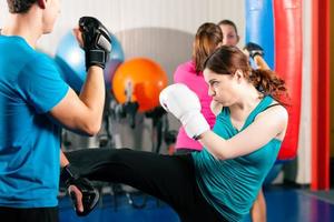 kick boxer femelle avec entraîneur en combat photo