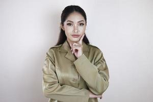 souriante belle femme asiatique pointant le doigt vers le haut pour un espace vide en studio fond isolé blanc photo