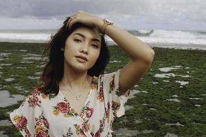 une belle jeune femme asiatique retournant ses cheveux à la plage photo