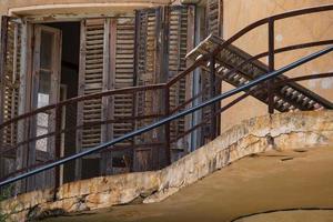 fenêtre en bois cassée et balcon d'une maison abandonnée dans la ville fantôme de varosha famagouste, chypre photo