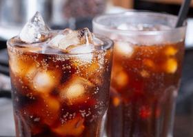 cola avec de la glace pilée dans du verre et il y a des gouttelettes d'eau autour. boisson fraîche noire fraîche. photo