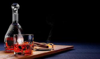brandy ou whisky dans un verre transparent avec des glaçons. boissons alcoolisées placées sur des sous-verres en bois. concept de boisson au bar cigarettes ou cigares placés dans le cendrier. rendu 3d. photo