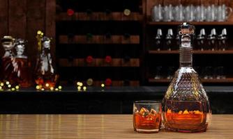 whisky ou brandy, boissons alcoolisées dans une élégante bouteille transparente. alcool en verre clair sur table de plancher en bois. plusieurs bouteilles de vin arrière-plan flou sur le comptoir du restaurant rendu 3d photo