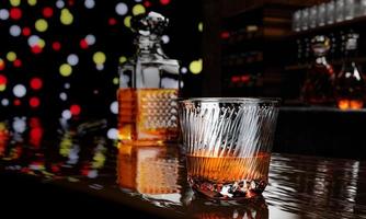 whisky ou brandy, boissons alcoolisées dans un verre élégant transparent. alcool en verre clair sur table de plancher en bois. plusieurs bouteilles de vin arrière-plan flou sur le comptoir du restaurant rendu 3d photo
