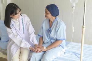 médecin tenant la main d'un patient âgé atteint d'un cancer à l'hôpital, soins de santé et concept médical photo