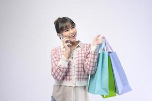 Attractive shopper woman holding shopping bags sur fond blanc photo