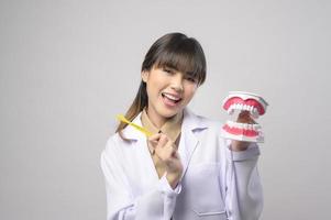 jeune femme dentiste souriant sur fond blanc studio photo