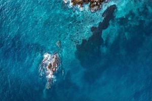 mer bleue et rochers sur l'île se forment au-dessus photo