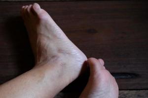 pieds féminins fermés avec des ongles français sur parquet, soins sains et concept médical photo