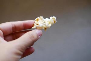 main tenant de délicieux pop-corn sucrés dans des sacs en plastique. photo