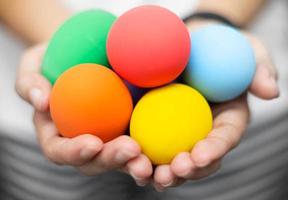 fermé des mains de femme tenant des oeufs de pâques colorés. concept de fête de pâques photo