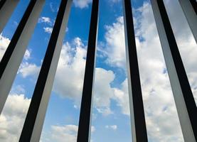 ciel bleu avec vue sur les nuages à travers la grille métallique. photo