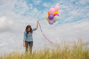 belle fille sautant avec des ballons sur la plage photo