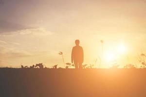 silhouette de femme priant sur fond de ciel magnifique photo