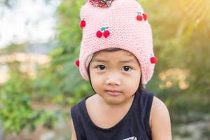 petite fille asiatique mignonne debout parmi le jour de soleil de champ de fleurs pourpres. la liberté de profiter de la nature. photo