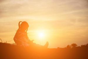 silhouette d'enfant, moments de joie de l'enfant. sur le coucher de soleil nature photo