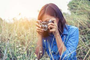 vintage de belles femmes photographie main debout tenant un appareil photo rétro avec lever de soleil, style doux de rêve