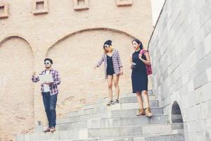 vacances d'été et groupe d'adolescents hipster voyageant ensemble dans une ville urbaine s'amusant et passant du bon temps ensemble. photo