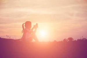 silhouette d'enfant, moments de joie de l'enfant. sur le coucher de soleil nature photo