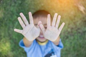 un enfant garçon mulâtre heureux sourit en appréciant la vie adoptée. portrait de jeune garçon dans la nature, le parc ou à l'extérieur. concept de famille heureuse ou d'adoption ou de parentalité réussie. photo