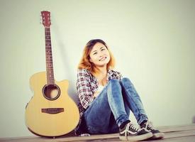 portrait de style femme hipster profiter avec guitare look si heureux. photo