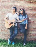 jeune homme hipster jouant de la guitare pour se détendre pendant ses vacances, profiter de l'air naturel et frais. photo