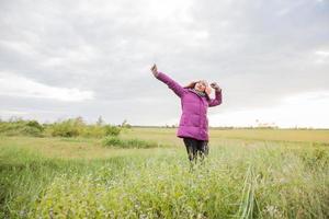 jeune femme jouait dans un champ de fleurs dans l'air hivernal. photo