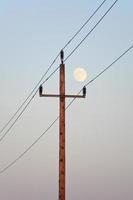poteau électrique avec lune montante photo