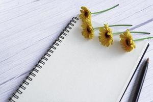 carnet de notes à plat avec des tournesols sur un bureau en bois. directement au-dessus. photo