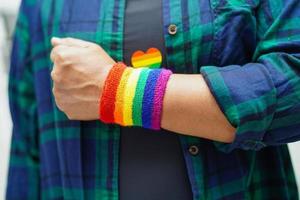 femme asiatique avec drapeau arc-en-ciel, droits des symboles lgbt et égalité des sexes, mois de la fierté lgbt en juin. photo