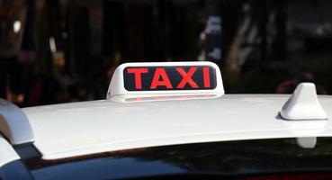 un panneau de taxi rouge sur un taxi dans la ville. photo