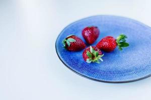 fraises dans une assiette bleue sur la table photo