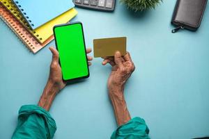 femmes âgées tenant une carte de crédit et utilisant un téléphone intelligent pour acheter en ligne photo