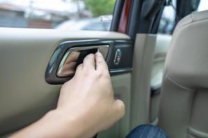 les mains de l'homme pour ouvrir la porte de la voiture de l'intérieur. photo