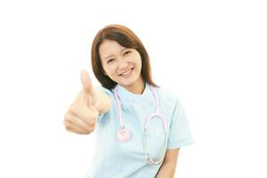 infirmière asiatique souriante avec les pouces vers le haut