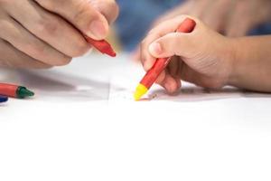 petite fille joue et apprend à colorier le crayon sur le papier dans le restaurant de crème glacée., bangkok, thaïlande. photo