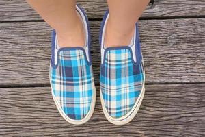 baskets en toile aux pieds sur le pont en bois photo