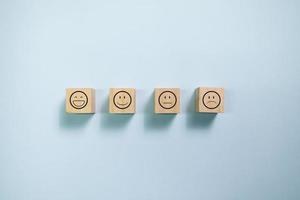 blocs de bois vue de dessus avec graphique de visage souriant. concept d'évaluation et de satisfaction client. photo
