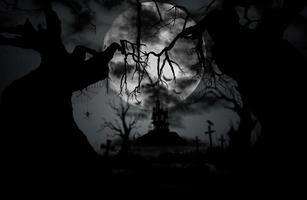 fond de nuit d'halloween avec lune, araignée, château, pierre tombale et vieil arbre. photo