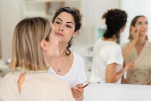 maquilleuse arabe maquiller une femme dans un centre de beauté. photo