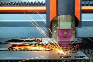 la machine de découpe laser fonctionne avec une plaque d'acier jusqu'à ce qu'elle étincelle sur une usine intelligente