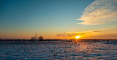 le beau coucher de soleil avec des pistes en fond d'hiver de neige photo