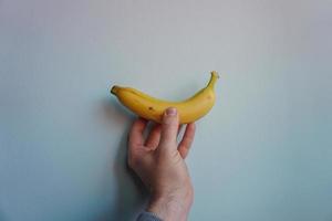 main tenant une banane, fruit sain photo