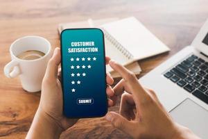 le client masculin donne une note de cinq étoiles sur son smartphone, sa satisfaction, son expérience de service client. revues de notation de service et concept d'enquête de satisfaction. photo