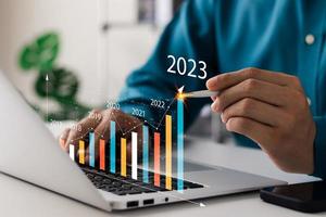 l'homme d'affaires analyse la rentabilité des entreprises en activité avec des graphiques de réalité augmentée numérique, des indicateurs positifs en 2023, l'homme d'affaires calcule les données financières pour les investissements à long terme. photo